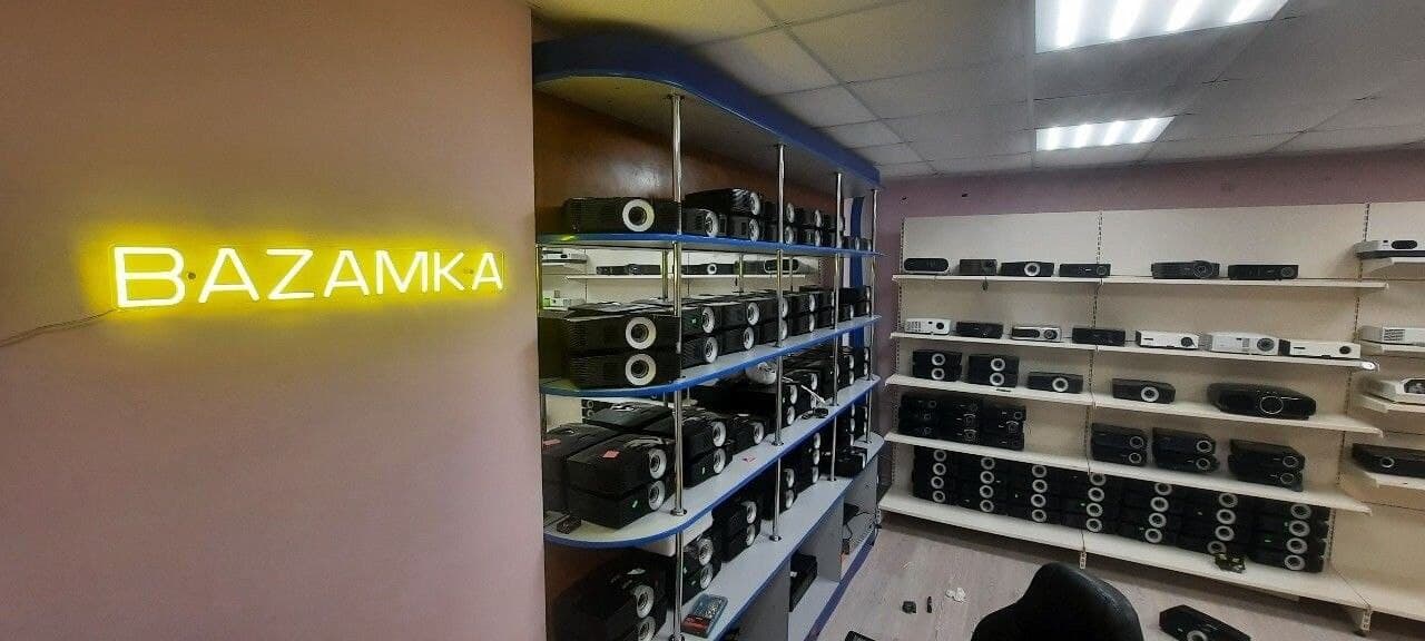 Магазин BAZAMKA - неоновая вывеска и стеллажи с проекторами